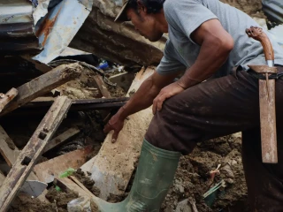 Seorang warga kembali ke rumah untuk mencari sisa barang-barang ditengah puing longsor di Desa Pandanarum, Kecamatan Pandanarum, Banjarnegara, Provinsi Jawa Tengah, Sabtu (22/11).