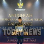 Mochammad Afifuddin saat menerima Anugerah Keterbukaan Informasi Publik dari Komisi Informasi Pusat.