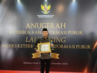 Mochammad Afifuddin saat menerima Anugerah Keterbukaan Informasi Publik dari Komisi Informasi Pusat.